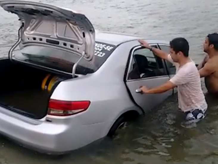 Carro arrastado por onda foi retirado com auxílio de cordas no Sul de SC (Foto: W3/Reprodução)